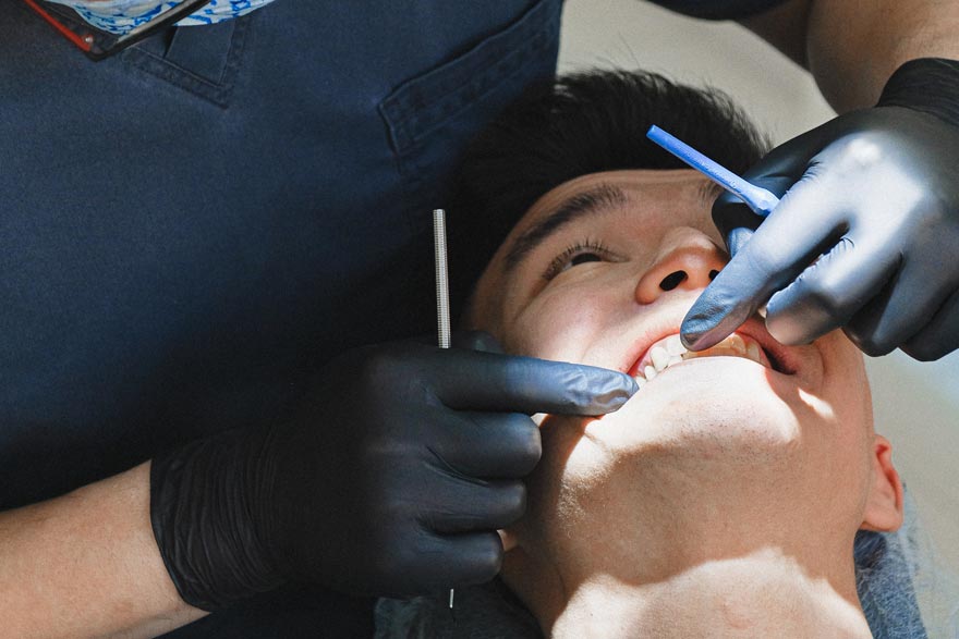 Dentista inspeccionando la gingivitis de su paciente