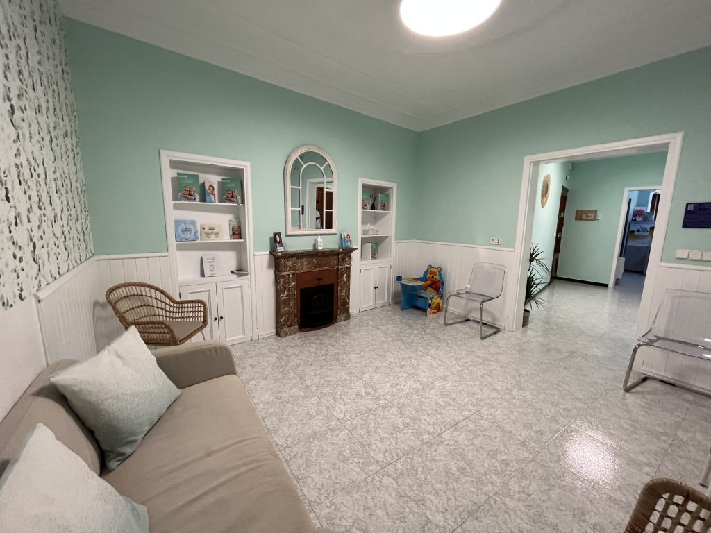 Sala de espera de la clínica con sofá y zona infantil